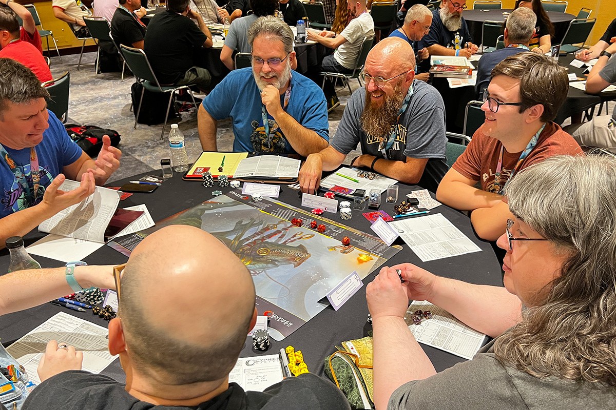 Players seated around a table demoing a tabletop game at GenCon